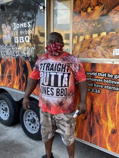 Mr. Jones standing in front of the food truck wearing a mask